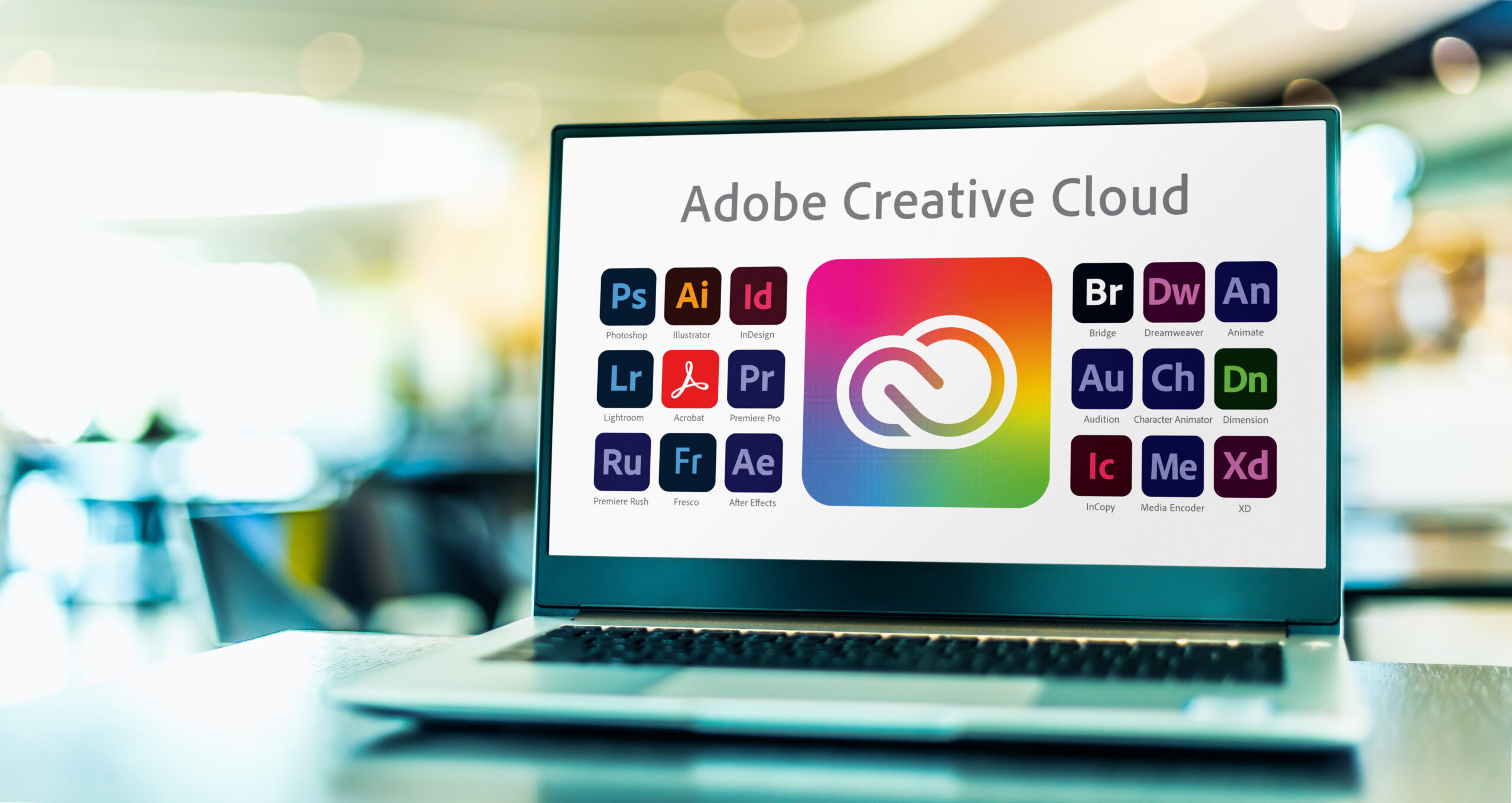 aptop computer displaying logotypes of Adobe Creative Cloud, a set of applications and services from Adobe Systems