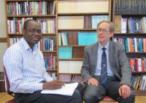 Clark University Ph.D. student Gbeton B. Somasse, left, meets with his adviser, Professor of Economics Wayne Gray.